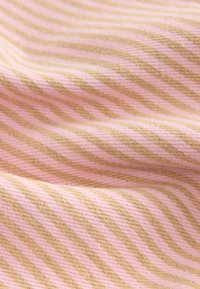 Textilie s tenkými růžovými a béžovými pruhy. Materiál má jemnou texturu a viditelný vzor tkaní, což vytváří útulný vzhled.