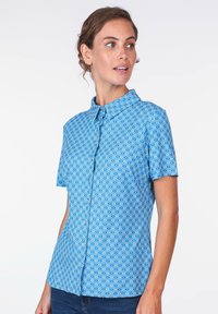 Kurzes blaues Hemd mit einem Muster aus weißen wellenförmigen Formen, Knopfleiste und klassischem Kragen. Glatte Stoffstruktur.