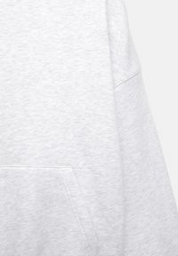 Jasnoszara bluza z długim rękawem, wykonana z teksturowanej tkaniny, z kieszenią typu kangur. Projekt jest prosty, z minimalną ilością szwów.