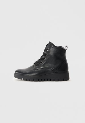 Zwarte leren enkelboots met een ronde neus, voorzien van metalen veterogen, zwarte veters en een gestructureerde rubberen zool. Inclusief een achterste trektab.