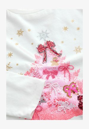 Cămașă albă din bumbac cu un design de brad de Crăciun roz, decorat cu paiete, panglici și accente de stea aurie, alături de elemente festive roz și aurii.