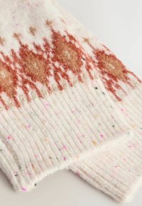 Strickschal aus weißer Wolle, mit einem geometrischen Muster in orange und pinken Sprenkeln, gerippte Details entlang der Kanten. Weiche, strukturierte Oberfläche.