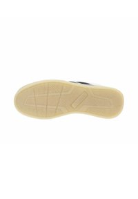 Suole delle scarpe con un design in gomma testurizzata di un beige chiaro, caratterizzate da motivi a zigzag e lineari per una migliore aderenza, con scanalature visibili lungo i bordi.