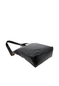 Sac fourre-tout en cuir noir avec bandoulière réglable et ferrures dorées, posé à plat sur un fond blanc.