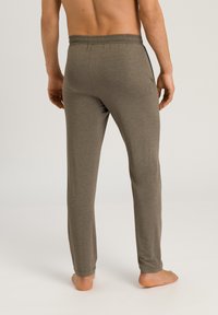 Mäns lätta, mjuka, grå joggingsbyxor med elastisk midja, avsmalnande ben och utan synliga fickor, designade för komfort.