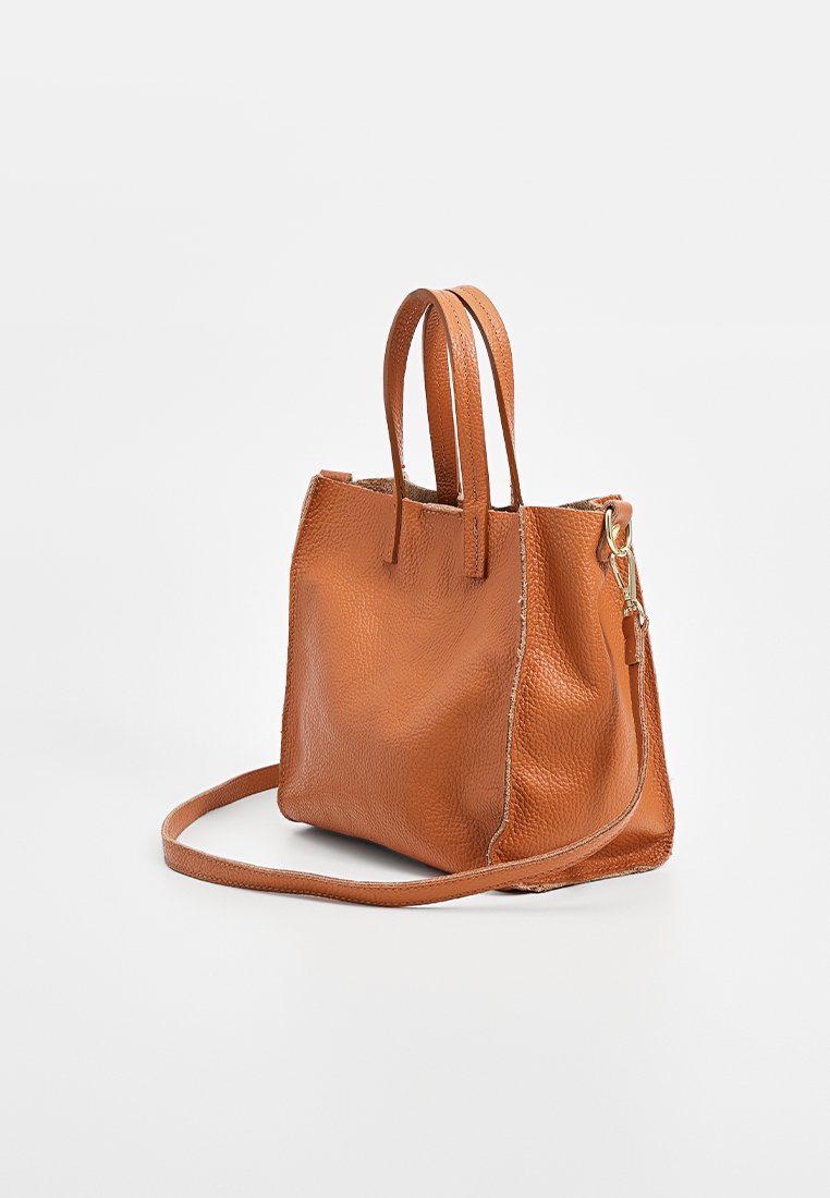 Leder-Handtasche in einem warmen Orangeton, mit zwei kurzen Griffen und einem abnehmbaren Schultergurt, strukturierte Oberfläche mit dezenten Nähten.