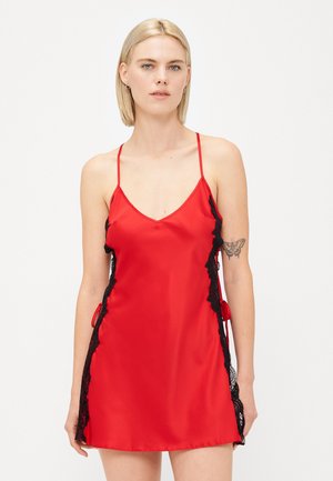 Rode satijnen slipdress met zwarte kantafwerking langs de zijkanten, dunne verstelbare bandjes en een V-hals ontwerp. Zachte textuur, knielang.