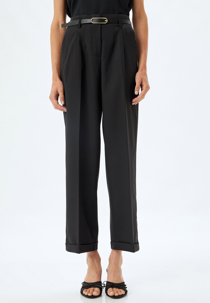 Pantaloni neri a vita alta con pieghe, cintura con fibbia dorata e orlo corto, realizzati in tessuto leggero e morbido.