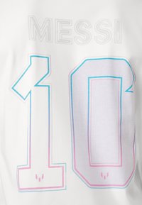 White T-shirt featuring the name "MESSI" above the number "10", in bold font with gradient pink and blue outline. Soft cotton texture.