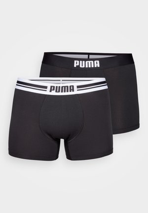 Boxers negros con cinturilla blanca de PUMA, con un ajuste ceñido y costuras planas, diseñados para comodidad y soporte.