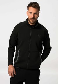 Schwarze Fleecejacke mit Reißverschluss und hohem Kragen, mit grauen seitlichen Akzenten und einem Logo auf der Brust. Glatte Textur, lockere Passform.