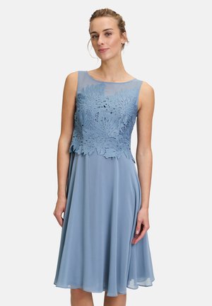 Ein knielanges, blaues Kleid aus leichtem Stoff, mit einem durchsichtigen, bestickten Oberteil mit Blumenmustern und einem ausgestellten Rock.