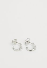 Silver hoop earrings with a curved design, featuring small clear crystals along one side and a post back for secure fastening.