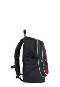 Černý batoh s červenými skvrnami, s více zipovými kapsami, polstrovanými popruhy a madlem na horní straně pro nošení nebo zavěšení.