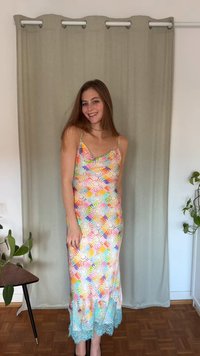 Flerfarget, ermeløs kjole med blomsterprint. Har dyp halsringning og en blondekant nederst. Glatt stoff og smal passform.