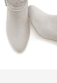 Botas de tobillo de ante gris con puntera puntiaguda, detalles de encaje en el borde superior y una cremallera con acentos en plata en un costado.