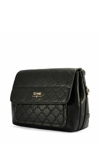 Czarna, pikowana torebka skórzana z klapką i złotym logo, widok pod kątem pokazujący boczny pasek i miękką konstrukcję.