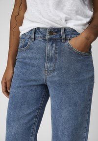 Denim jeans i lyseblå med tapered ben, med knappeåpning, fem lommer og kontrasterende oransje søm.