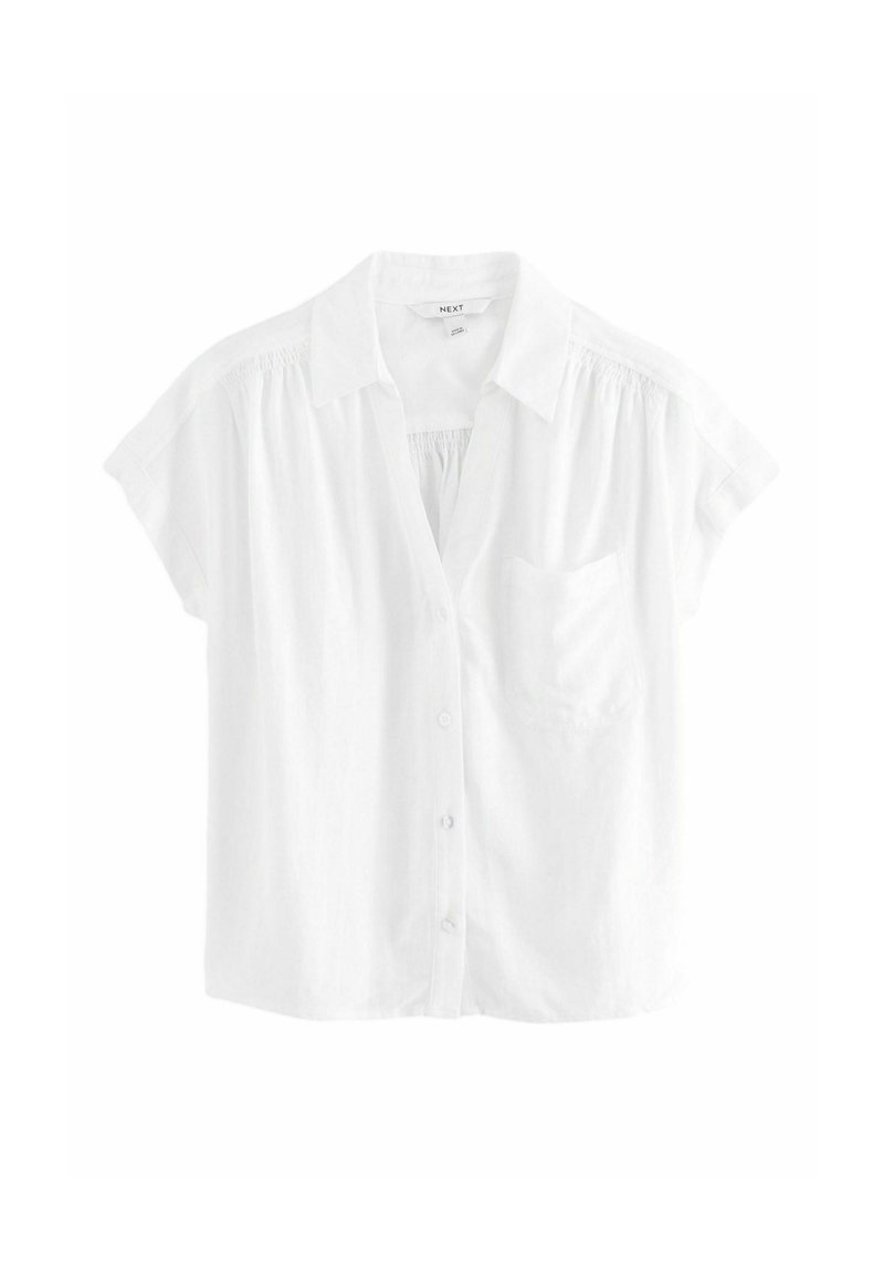 Camicia bianca a maniche corte con chiusura a bottoni, colletto e taschino sul petto; realizzata in tessuto leggero con una vestibilità leggermente ampia.