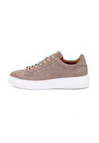 Baskets en daim beige avec une semelle en caoutchouc blanc, dotées de lacets beige, d'un bout arrondi et d'un design minimaliste. Texture lisse et lignes épurées.