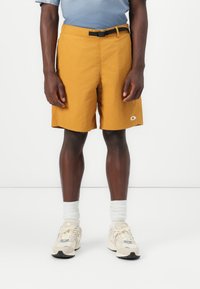 Men's mustard yellow shorts, lightweight fabric, straight-cut design, waistband with black belt, featuring a small logo on the hem.