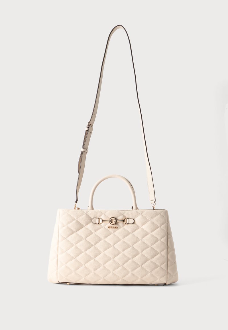 Sac à main matelassé crème avec des poignées courtes et une longue bandoulière ajustable, featuring un petit logo doré et des garnitures décoratives à l'avant.