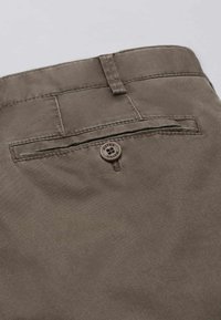 Pantaloni in tessuto marrone con una tasca posteriore standard, dotati di chiusura a bottone e dettagli di cucitura discreti. Materiale in tela testurizzata.