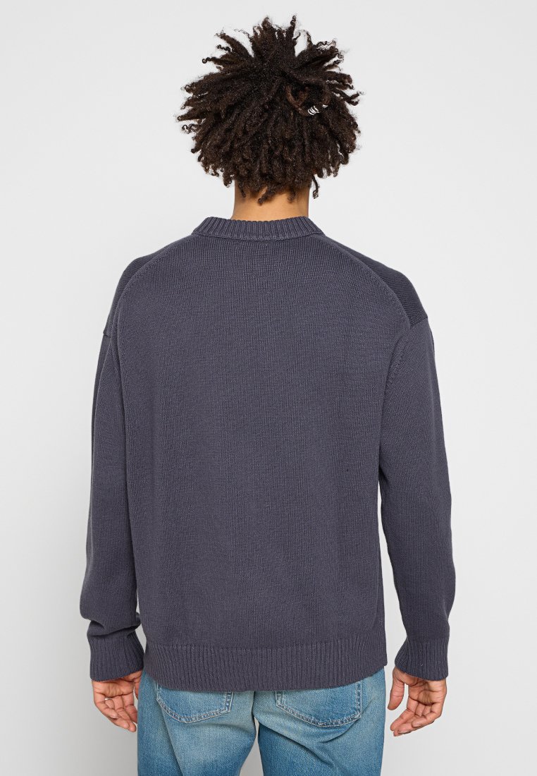 Maglione lavorato a maglia blu navy con collo a girocollo a coste, maniche lunghe e tessuto testurizzato, caratterizzato da pannelli sulle spalle a contrasto.