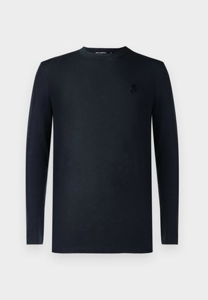 Fekete, hosszú ujjú, kerek nyakú póló, melyen diszkrét logó található a bal mellrészen, sima anyagból készült, egyszerű fehér háttérrel bemutatva.