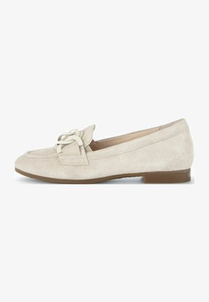 Beige Veloursleder Slipper mit runder Zehenform, ausgestattet mit einem dekorativen Schnürdetail und einem niedrigen braunen Absatz. Glatte Textur und minimales Design.