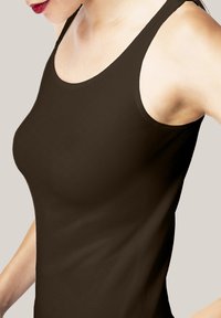 Brun ärmlös topp med en figurnära design, slät textur och rund halsringning. Tyget verkar töjbart och mjukt.