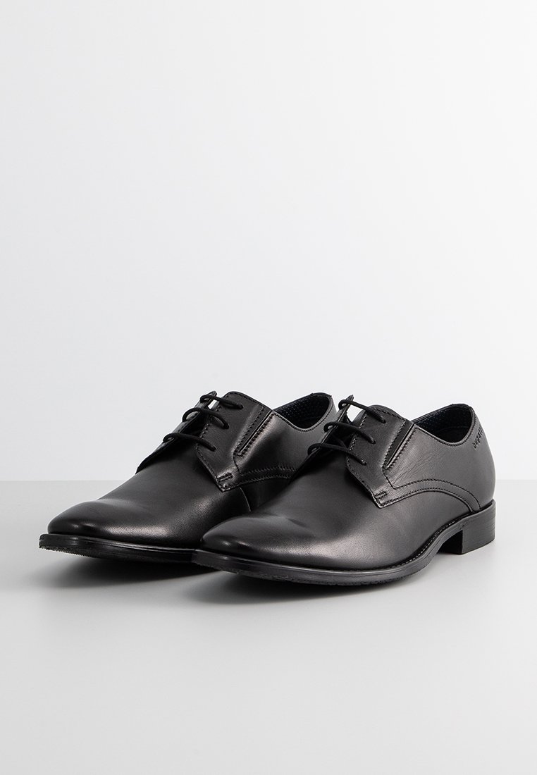 Schwarze Lederschuhe mit glatter Textur, spitzem Zeh und Schnürverschluss. Minimalistisches Design mit niedrigem Absatz. Dezente Steppnaht.