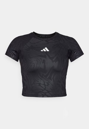 Camiseta deportiva negra recortada con un patrón texturizado, mangas cortas y un logo blanco en el pecho. El material parece suave y flexible.