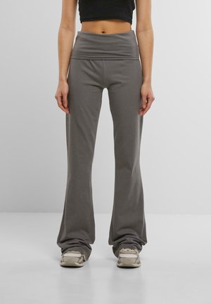 Pantalons évasés gris avec une taille haute, fabriqués dans un tissu doux, présentant une coupe ample et une texture froncée aux chevilles.