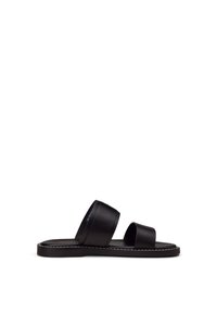 Schwarze Leder-Slide-Sandale mit zwei breiten Riemen und flacher Sohle, die entlang des Randes weiße Nähte aufweist, im Profil vor weißem Hintergrund dargestellt.