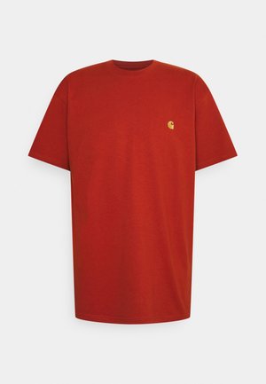 T-shirt rouge à manches courtes avec col rond et petit logo jaune sur la poitrine gauche, design simple, présenté sur fond blanc.