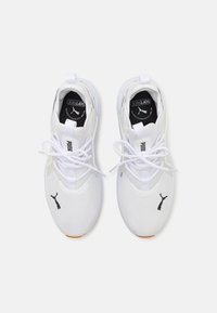 Hvide mesh sneakers med sort Puma-logo, der har en rund tå, snørret front, polstret krave og tekstureret sål.