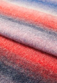 Tejido de lana con gradiente que presenta texturas suaves en tonos de rosa, rojo y púrpura, con un acabado liso y transiciones de color difuminadas.