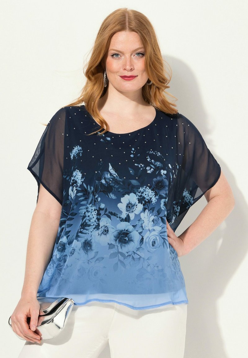 Transparente navyblaue Bluse mit floralem Muster in Blautönen, verziert mit kleinen Nieten, weiten kurzen Ärmeln und einem runden Ausschnitt.