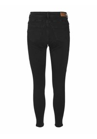 Jeans negros ajustados con una cintura alta, que cuentan con dos bolsillos traseros y una tela texturizada. El diseño enfatiza una silueta elegante y ceñida.