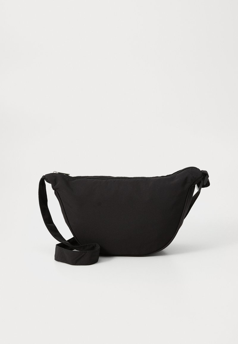 Saco hobo preto feito de tecido macio, com uma forma curvada, fecho com zipper e uma alça larga e ajustável. Textura suave sem padrões.