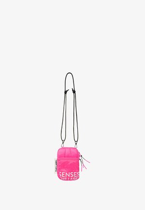 Pink padded crossbody bag with black adjustable straps and white printed text. Zipper closure with decorative pulls. Compact rectangular shape.