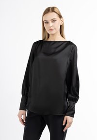 Schwarze Satinbluse mit langen Ärmeln, rundem Ausschnitt und leicht gerafften Manschetten. Glatte Textur und minimalistisches Design.