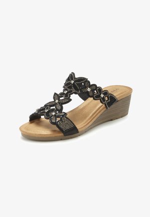 Black wedge sandal with beige sole, decorated with intricate beaded floral straps and a stacked heel.