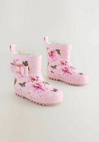 Bottes de pluie en caoutchouc rose avec un motif floral comprenant des fleurs roses et des papillons, semelles texturées et un accent en nœud sur le côté extérieur.