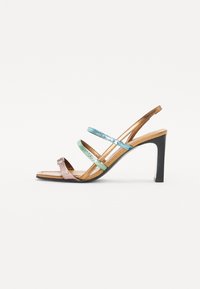 Sandale à talon ouvert avec trois brides métalliques en rose, bleu et vert. Talon brun élancé, semelle intérieure lisse et design minimaliste.
