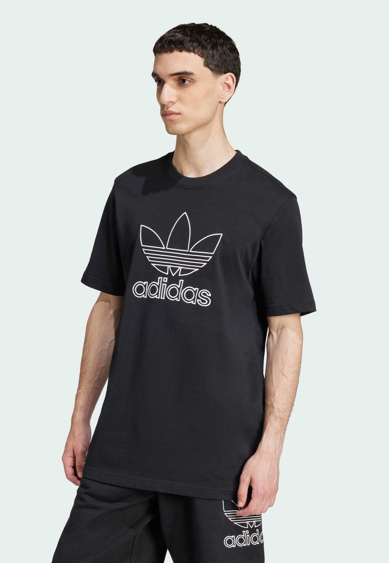 T-shirt in cotone nero con logo Adidas bianco e design trefoil. Maniche corte, scollatura rotonda e taglio rilassato.