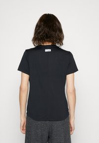 Camiseta negra de manga corta con escote redondo, textura suave y una etiqueta en la parte superior de la espalda. Cuenta con un dobladillo ligeramente curvado.