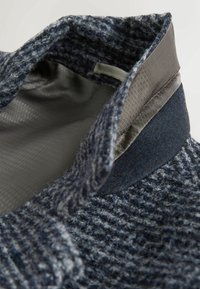 Guler de pulover tricotat în tonuri de bleumarin și gri, țesătură texturată cu căptușeală interioară netedă, având un design structurat, vertical.