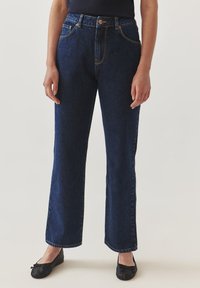 Jeans de mezclilla de corte amplio en azul oscuro, con una cintura alta, cinco bolsillos, costuras de contraste y cierre de botón.